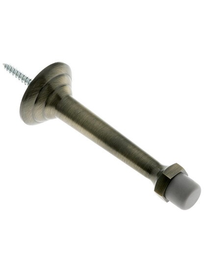 3 3/4 inch Stepped Base Door Stop With Dark Grey Tip in Antique Brass.